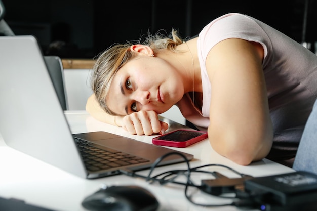 Photo of person business woman working at home office on laptop looking worried tired and stressed