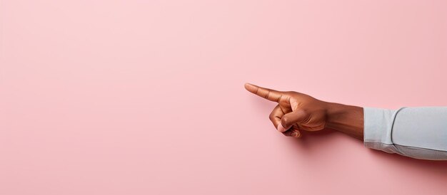 Photo of a person pointing at something on a vibrant pink background with copy space