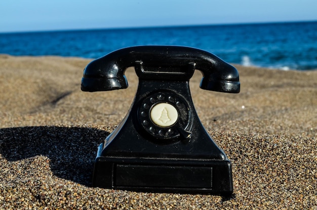 Фотография старого телефона на песчаном пляже