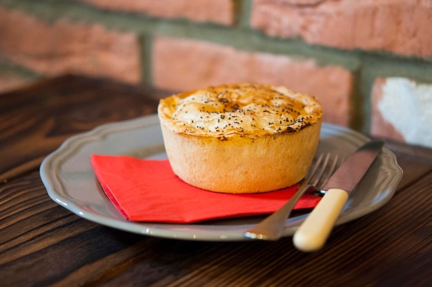 Photo photo of pie taken on a wooden table and brick background