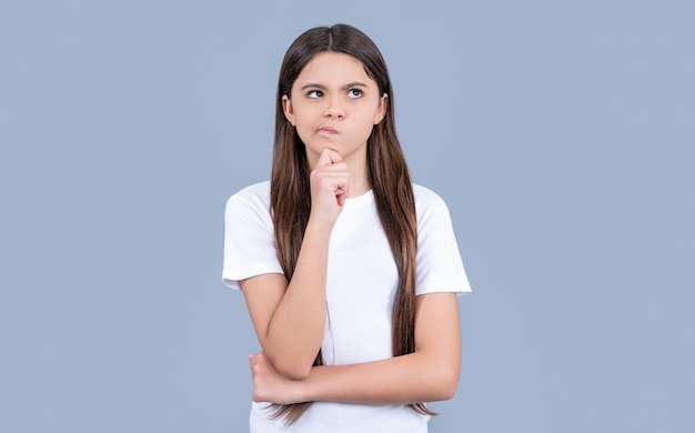 Photo of pondering teen girl with long hair wearing tshirt teen girl isolated on grey