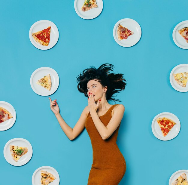 Photo photo in pop art style a girl with a lot of pizza on a colored backgroundxa