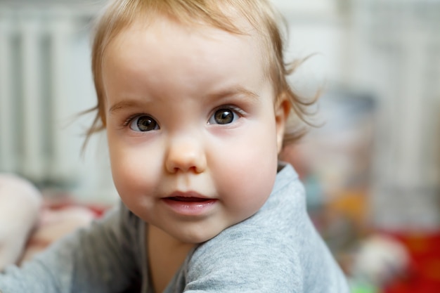 ピンクの頬を持つ女の赤ちゃんの写真の肖像画。赤ちゃんは立ち上がる