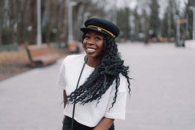 Photo photo portrait of cheerful black skinned girl in a city park.