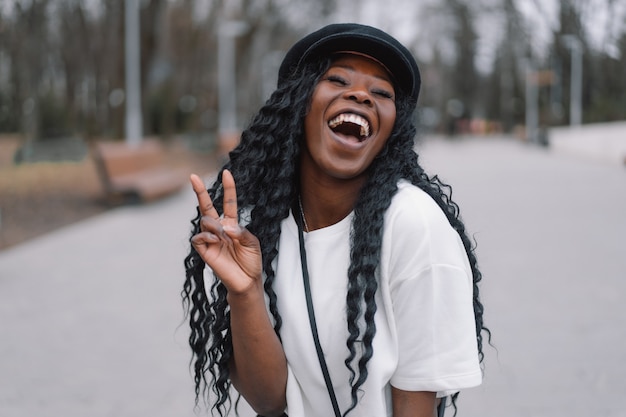 Photo portrait of cheerful black skinned girl in a city park. 