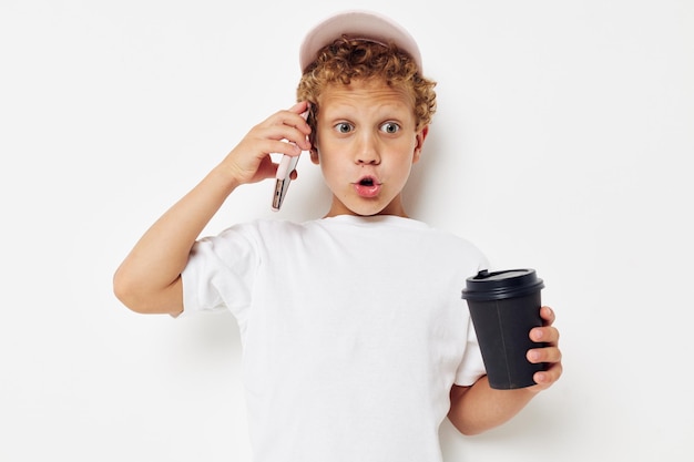 Photo portrait curly little boy talking on the phone with a black glass isolated background unaltered