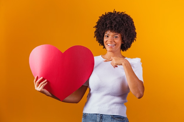 Photo portrait of smiling afro woman holding big red heart card