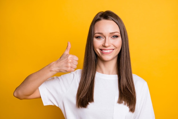 Photo portrait of woman giving thumb up isolated on bright yellow colored background