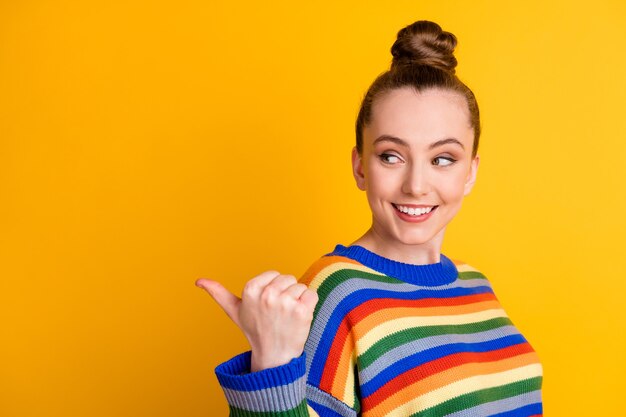 Photo of positive cheerful girl promoter point forefinger copyspace demonstrate ads promotion choice decision advice wear pullover isolated over bright color background