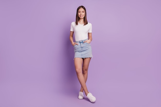 Photo of positive cheerful pretty cute lady crossed legs posing on violet background