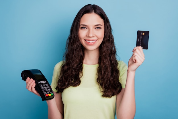 Photo of positive reliable lady demonstrate debit card portable wireless terminal on blue background