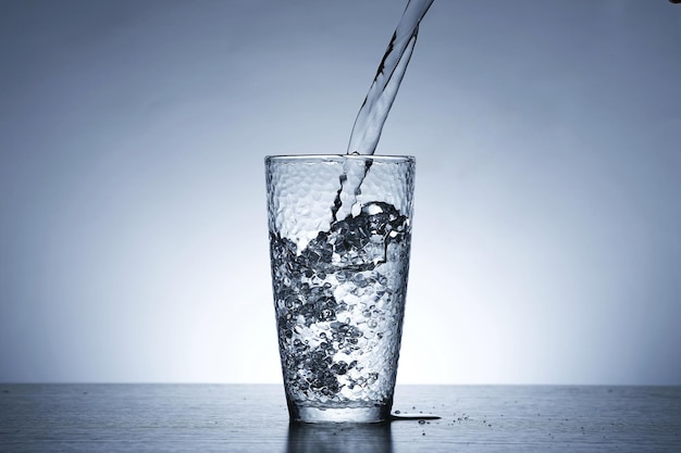 Foto foto di versare l'acqua in un bicchiere d'acqua