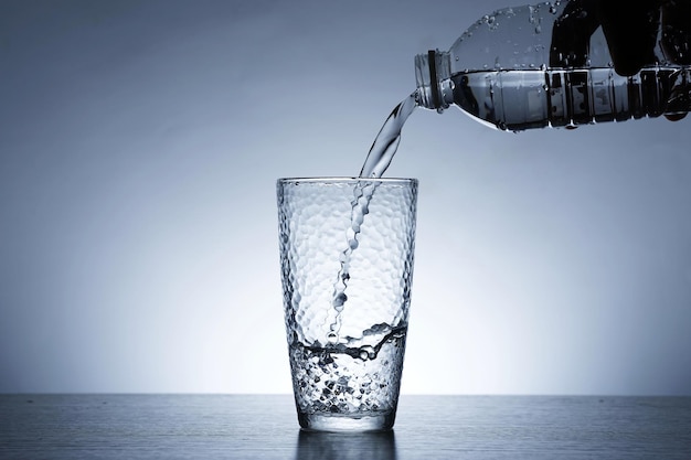 Photo of pouring water into a glass of water