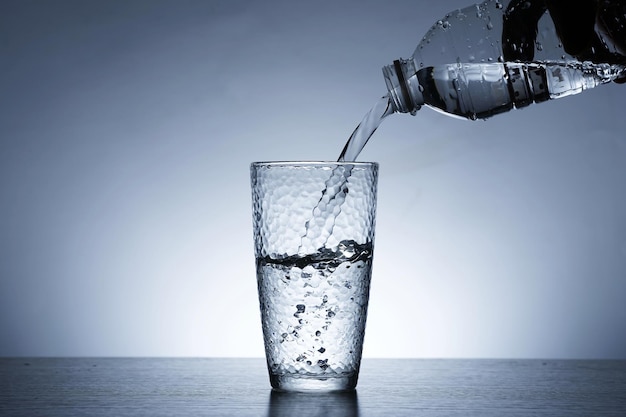 Photo of pouring water into a glass of water