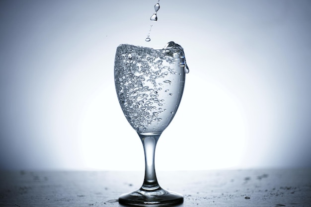 Photo of pouring water into a glass of water