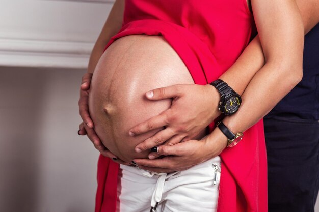 Photo of pregnant woman belly Hands hugging pregnant belly Close up of human hands holding pregnant belly Pregnant woman hugs her belly Pregnancy Pregnancy Concept