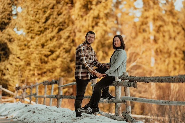 Photo of pretty adorable girlfriend and boyfriend dressed casually A woman sitting on the edge of a fence Selective focus