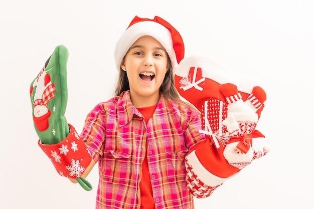 La foto della ragazza abbastanza affascinante tiene il fondo bianco isolato del presente di natale della calza del nuovo anno.