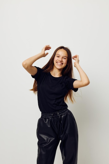 Photo pretty girl in black pants and a Tshirt fashion light background