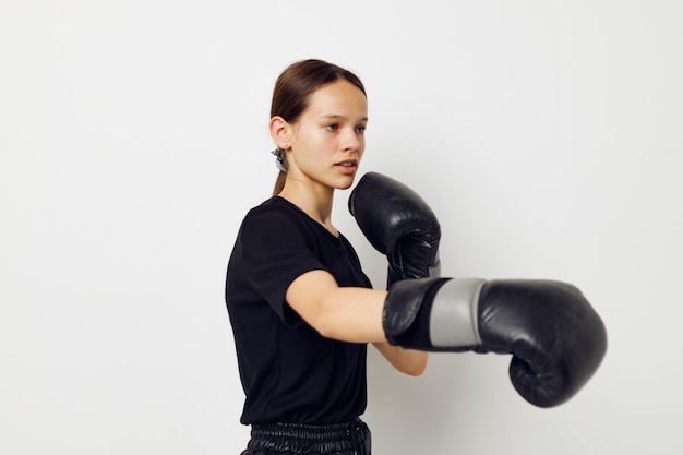 Photo pretty girl in boxing gloves in black pants and a Tshirt fitness training