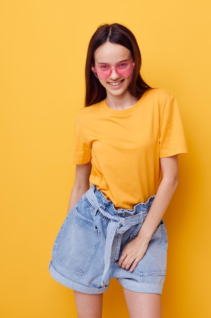 Photo pretty girl fashion in yellow tshirt denim shorts isolated background