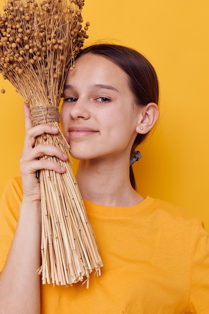 Photo pretty girl fashion in yellow tshirt dried flowers bouquet posing isolated background