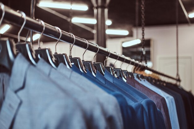 Foto di un rack con giacche da abito in un negozio di abbigliamento maschile.