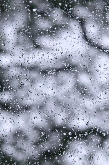 A photo of rain drops on the window glass with a blurred view 