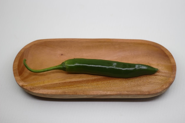Фото Фото сырой большой зеленый перец чили на деревянном подносе