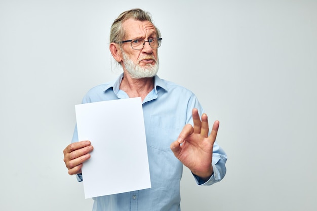 Photo of retired old man holding a sheet of paper copyspace posing isolated background