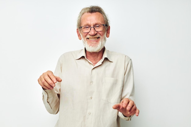 Photo of retired old man with a gray beard in a shirt and glasses light background