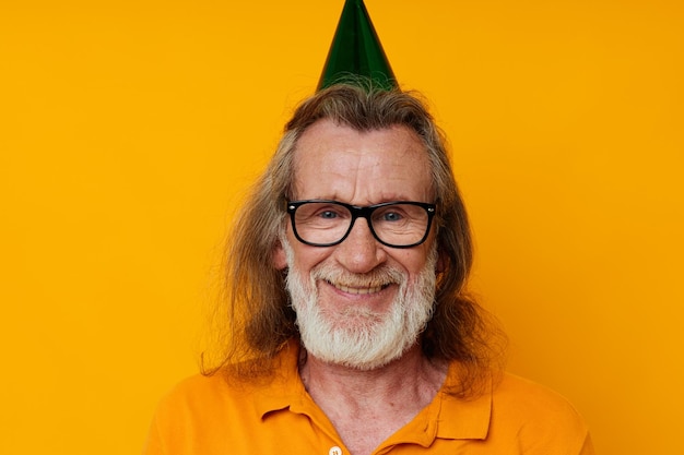 Photo of retired old man in a yellow tshirt with a cap on his head fun cropped view