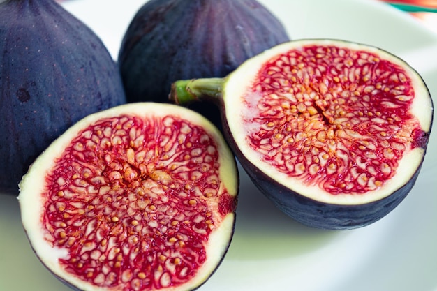 Photo of ripe figs in a cut close-up. Red pulp and grains of ripe purple figs.