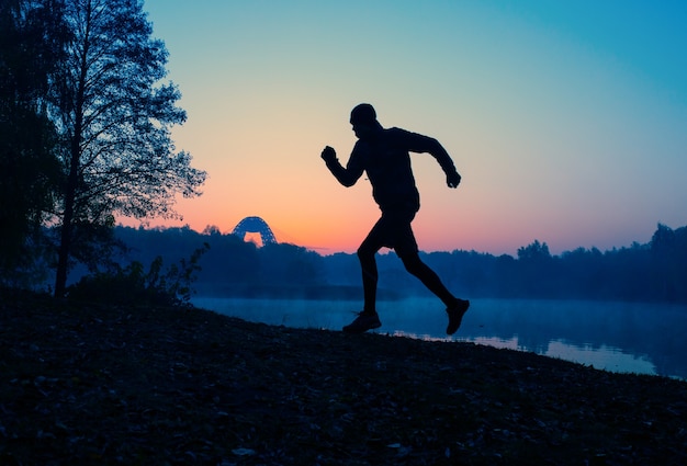 日没時のランニングアスリートの写真