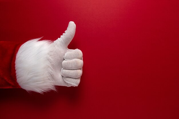 Photo of Santa Claus gloved hand is showing thumb up