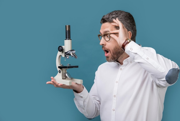 Photo of shocked man holding microscope invention man with invention microscope