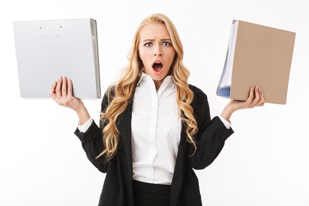 Photo of shocked manager girl wearing office suit holding paper folders in hands, isolated