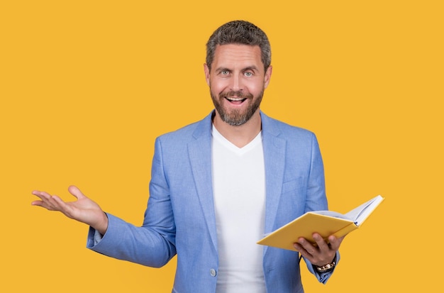 Photo of shocked teacher reading book teacher reading book isolated on yellow background