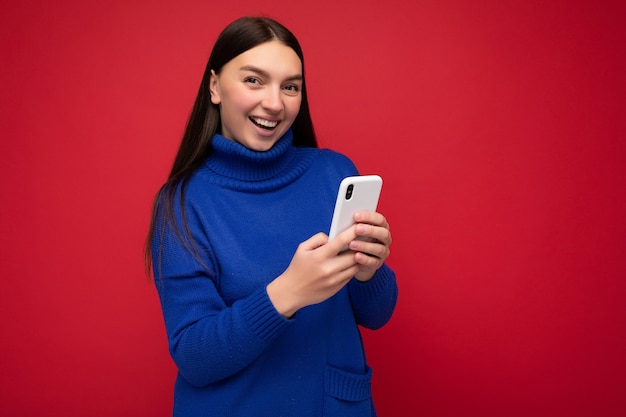 Photo shot of attractive positive good looking young woman wearing casual stylish outfit poising