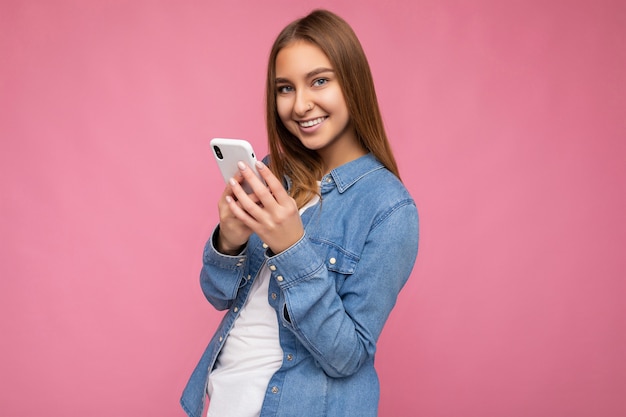 Photo shot of attractive positive good looking young woman wearing casual stylish outfit poising