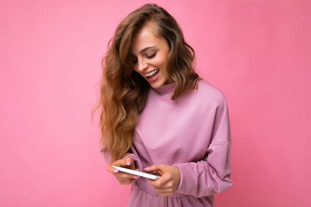 Photo shot of attractive positive good looking young woman wearing casual stylish outfit poising