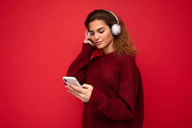 Photo shot of beautiful joyful smiling young female person wearing stylish casual outfit isolated