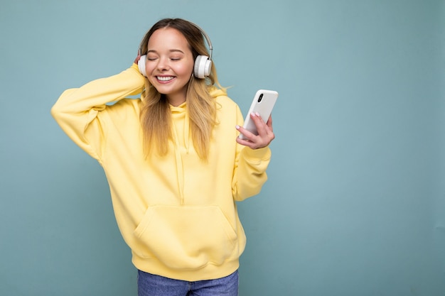 Photo shot of beautiful joyful smiling young female person wearing stylish casual outfit isolated