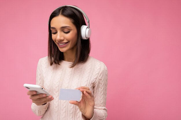 Photo shot of beautiful joyful smiling young female person wearing stylish casual outfit isolated