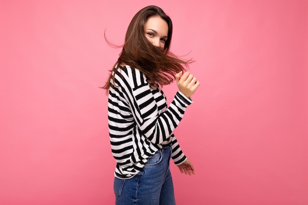 Photo shot of cute attractive pretty young brunette woman wearing casual striped longsleeve isolated over colorful background with copy space.