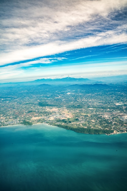 タイ中部のビーチと海のそばの広い街を撮影したジェット機からの写真。