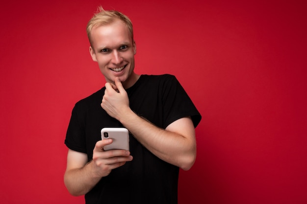 Photo shot of handsome positive good looking young man wearing casual stylish outfit poising