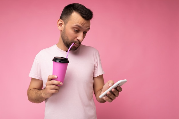 Scatto fotografico di un bel giovane di bell'aspetto positivo che indossa abiti casual ed eleganti in bilico