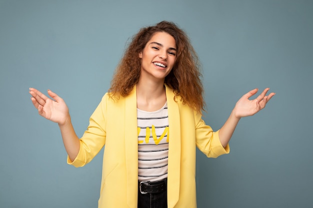 Photo shot of young smiling positive happy attractive brunette curly woman with sincere emotions