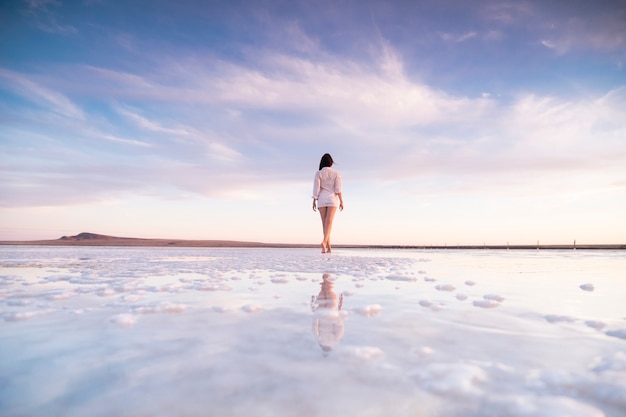 Photo photo of a slender woman from the back with reflection in the water.